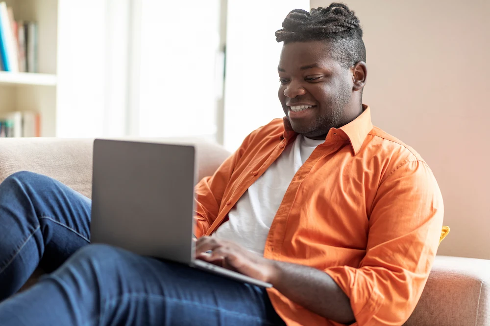 Young overweight man typing on laptop