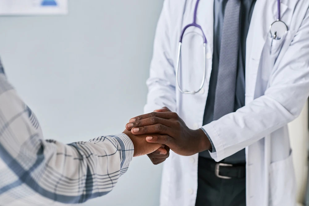 Doctor holding patient's hand