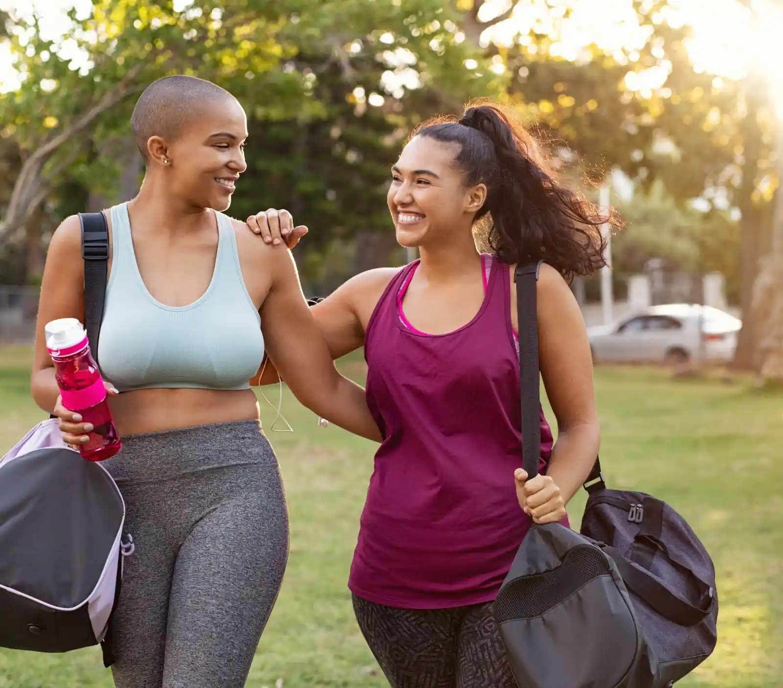 Two women walking with duffle bags after workout