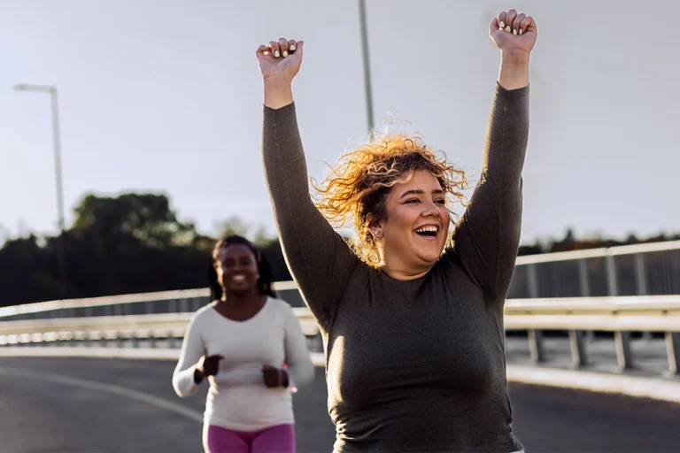 Two excited plus size women feeling accomplished after jogging