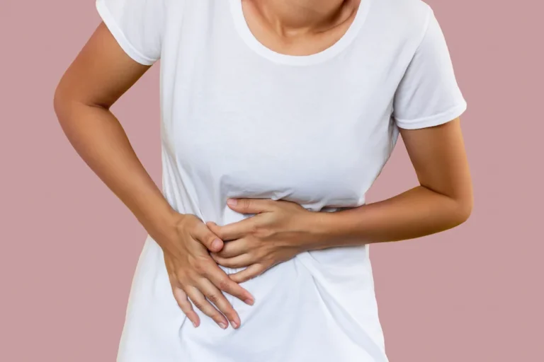 woman holding the side of her abdomen because of gallbladder pain
