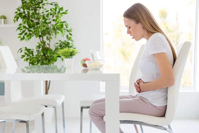 woman holding abdomen in pain after eating
