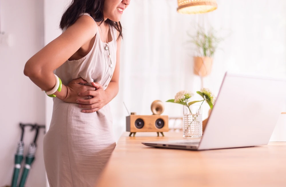 Woman holding her side and wincing in pain