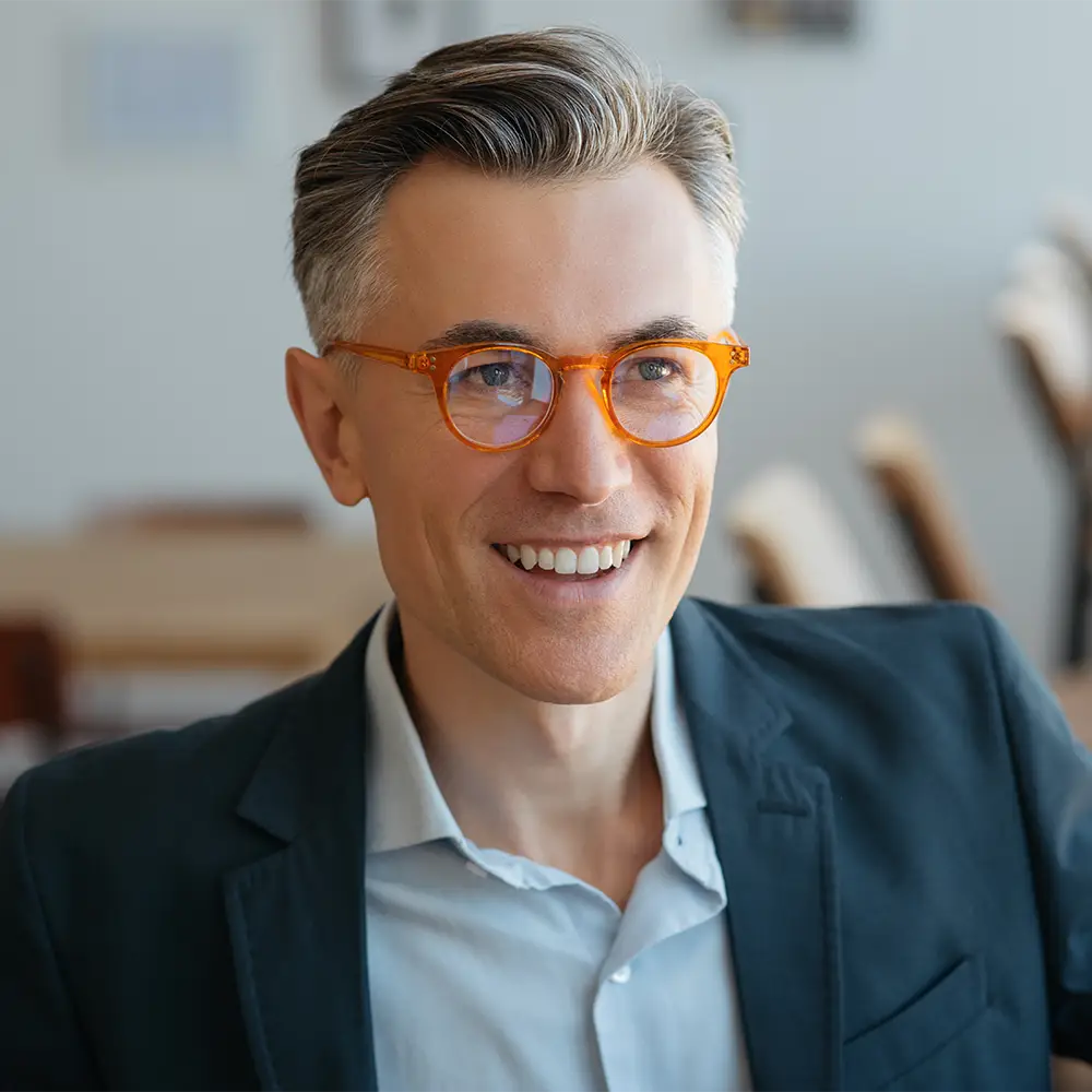middle aged man with great hair in office smiling