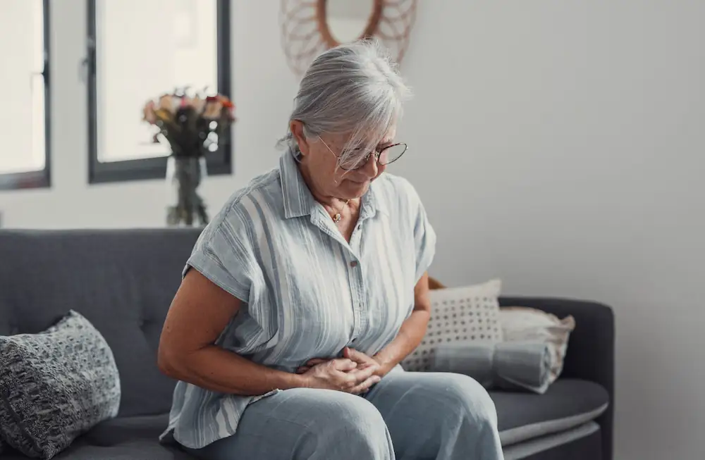 older woman holding her stomach in pain