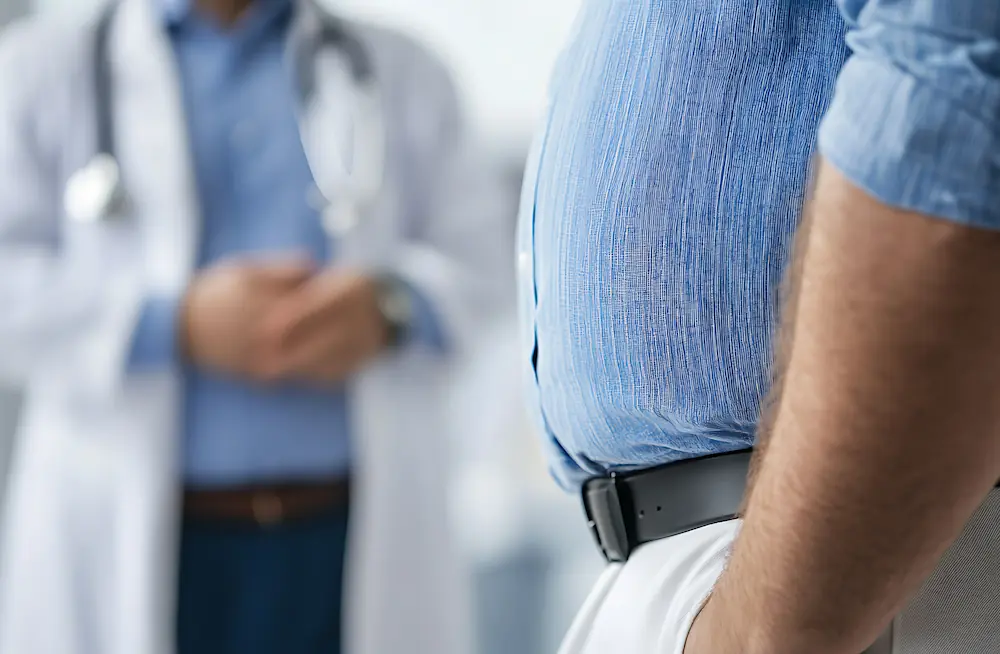 man suffering from weight gain talking to his doctor