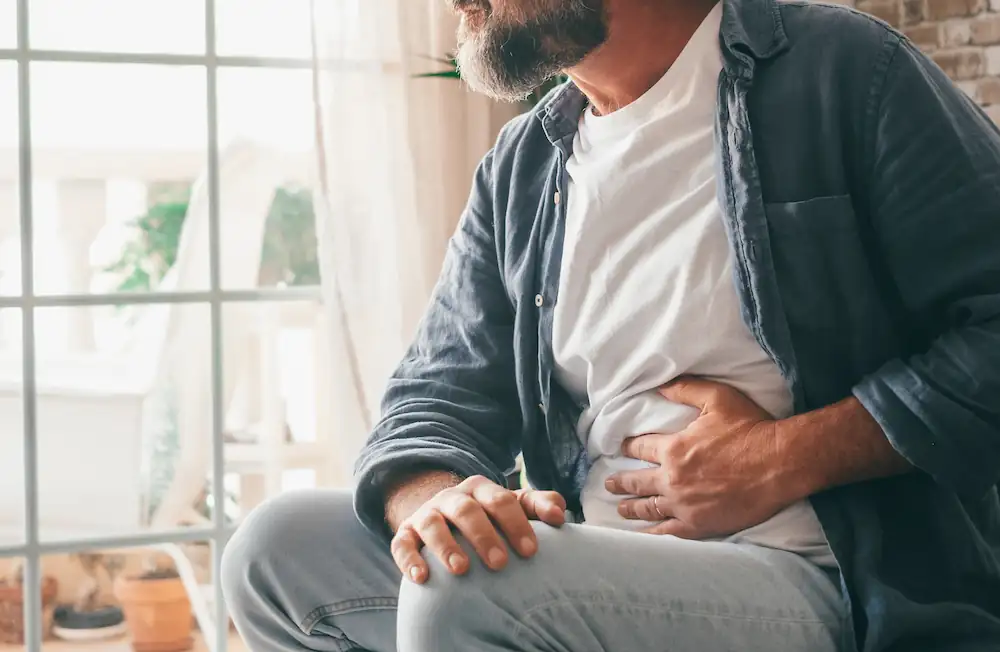 man holding his abdomen in pain